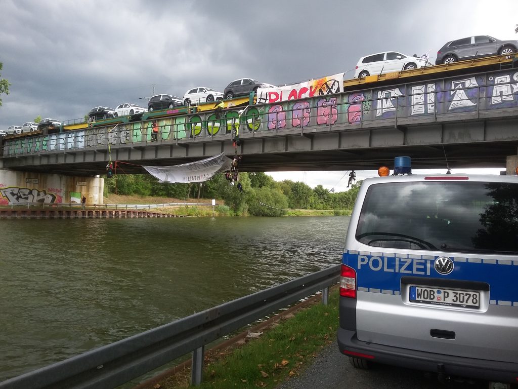 Aktivist*innen seilen sich von der Brücke ab, ihr Transparent ist nicht lesbar.