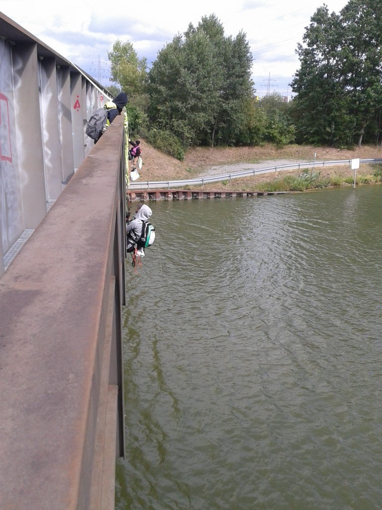 Menschen klettern an der Seite der Brücke herum.